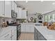 Bright kitchen with white cabinets, stainless steel appliances, and island, open to the living room with fireplace at 169 Rooster Tail Ln, Troutman, NC 28166