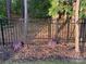 Close-up of attractive landscape design featuring a decorative wrought iron fence, flowering bushes, and fresh mulch at 169 Rooster Tail Ln, Troutman, NC 28166