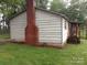 View of the home's exterior showing the brick chimney, siding and screened-in porch at 1700 Old Spencer Mountain Rd, Dallas, NC 28034