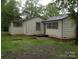 Exterior view of a quaint single-story home with a well-maintained lawn surrounded by lush trees at 1700 Old Spencer Mountain Rd, Dallas, NC 28034