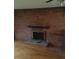 Cozy living room highlighting a brick fireplace and hearth with hardwood flooring at 1700 Old Spencer Mountain Rd, Dallas, NC 28034
