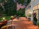 Evening shot of a spacious back deck featuring outdoor seating and manicured landscaping at 19205 Hidden Cove Ln, Cornelius, NC 28031
