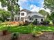 Expansive backyard with lush lawn, mature trees, a large deck, and meticulous landscaping for outdoor enjoyment at 19205 Hidden Cove Ln, Cornelius, NC 28031