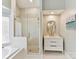 Bright bathroom featuring a glass-enclosed shower, a vanity with a marble countertop, and an accent mirror at 19205 Hidden Cove Ln, Cornelius, NC 28031