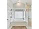 A luxurious bathroom with a large soaking tub, a glass-enclosed shower, and a decorative rug at 19205 Hidden Cove Ln, Cornelius, NC 28031