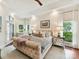 Comfortable bedroom with tufted headboard, neutral colors, bedside tables and a large window at 19205 Hidden Cove Ln, Cornelius, NC 28031