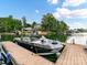 Modern boat docked on a peaceful lake with lush greenery and beautiful waterfront homes in the background at 19205 Hidden Cove Ln, Cornelius, NC 28031