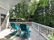 Inviting deck with comfortable blue chairs, a small accent table, and privacy fence amidst a lush green landscape at 19205 Hidden Cove Ln, Cornelius, NC 28031