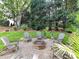 Cozy fire pit area with Adirondack chairs surrounded by trees and lush landscaping at 19205 Hidden Cove Ln, Cornelius, NC 28031