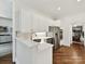 Bright kitchen with white cabinets, marble counters, stainless appliances and hardwood floors at 19205 Hidden Cove Ln, Cornelius, NC 28031