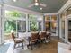 Bright sunroom with walls of windows, tiled floors, a ceiling fan, and a large farmhouse dining table with seating at 19205 Hidden Cove Ln, Cornelius, NC 28031