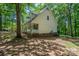 View of the side of the home with brick foundation and mature trees at 203 Hickory Wood Dr, Kannapolis, NC 28083
