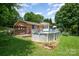 Backyard features an above-ground pool with deck, lounge chairs, and brick patio, surrounded by lush lawn and mature trees at 2109 Quail Nw Dr, Concord, NC 28027