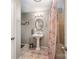 Bathroom featuring a pedestal sink, oval mirror, updated fixtures, and tiled floors with colorful shower curtain at 2109 Quail Nw Dr, Concord, NC 28027