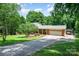 Charming home with brick accents, mature trees, extended driveway and covered porch in a lush, serene setting at 2109 Quail Nw Dr, Concord, NC 28027