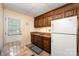 Compact kitchen featuring wooden cabinets, laminate countertops, and a door to the backyard at 2109 Quail Nw Dr, Concord, NC 28027