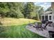 Inviting backyard with a stone patio and a built-in fire pit and green lawn at 220 Holmes Ct, Concord, NC 28027