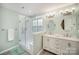 Bright bathroom features a double vanity, modern lighting, glass shower and sleek tile at 220 Holmes Ct, Concord, NC 28027