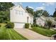 View of a well-manicured lawn and driveway leading up to a cream-colored two-story house with an attached garage at 220 Holmes Ct, Concord, NC 28027