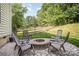 Comfortable outdoor seating around a stone fire pit and tree lined yard at 220 Holmes Ct, Concord, NC 28027