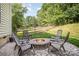 Outdoor seating around a cozy fire pit on the patio and tree lined yard at 220 Holmes Ct, Concord, NC 28027