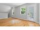Bonus room with hardwood floors, neutral paint, and two windows with a door to the outside at 220 Plonk Rd, Dallas, NC 28034