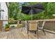 Outdoor patio featuring a round table with four chairs, under an umbrella, with green surroundings at 220 Plonk Rd, Dallas, NC 28034