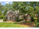 Charming brick home with mature trees, lush landscaping, and manicured lawn at 2241 Flagstick Dr, Matthews, NC 28104