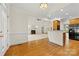 Open concept kitchen and living space, featuring fireplace, modern appliances, and warm hardwood floors at 2241 Flagstick Dr, Matthews, NC 28104