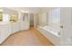 Elegant main bathroom with a soaking tub, a glass shower, and double sink vanity at 2241 Flagstick Dr, Matthews, NC 28104