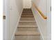 Carpeted staircase with wooden handrail, leading to the next level of the home at 2241 Flagstick Dr, Matthews, NC 28104