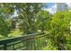 A quaint balcony overlooking a green park with lush trees and a nearby church at 229 N Church St # 401, Charlotte, NC 28202