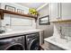 Well-lit laundry room with modern front-loading washer and dryer, granite countertops, and subway tile backsplash at 229 N Church St # 401, Charlotte, NC 28202