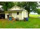 Backyard view of cozy home featuring green yard, sheds, and mature landscaping at 238 Deaton St, Statesville, NC 28677