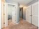 Well-lit hallway with multiple doorways and neutral carpeting at 3009 Canopy Dr, Indian Trail, NC 28079