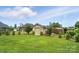 Expansive backyard with lush lawn and detached garage enclosed by a classic black metal fence at 3256 Fairmead Dr, Concord, NC 28025