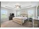 This is a primary bedroom featuring tray ceilings, neutral walls, dual windows and a ceiling fan at 3256 Fairmead Dr, Concord, NC 28025
