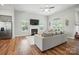 Bright living room features a fireplace, large TV, wood floors, and comfortable seating at 3256 Fairmead Dr, Concord, NC 28025