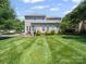 A large backyard with mature trees, green grass, and a multi-level deck at 3301 Old Knobbley Oak Dr, Gastonia, NC 28056