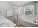 Bright bathroom featuring a glass shower, soaking tub, and double vanity with earth-toned tile flooring at 3301 Old Knobbley Oak Dr, Gastonia, NC 28056