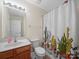 Compact bathroom featuring a wood vanity, neutral walls, and a shower/tub combo with a cactus-themed shower curtain at 3301 Old Knobbley Oak Dr, Gastonia, NC 28056