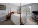 Cozy bedroom features a four-poster bed, bedside table, and sun-filled windows at 3301 Old Knobbley Oak Dr, Gastonia, NC 28056