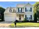 Charming two-story home with a well-manicured lawn, two-car garage, and inviting front porch with rocking chairs at 3301 Old Knobbley Oak Dr, Gastonia, NC 28056