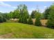 Well-kept backyard with green lawn, privacy wall, and mature trees, perfect for outdoor enjoyment at 3308 Carmel Rd, Charlotte, NC 28226