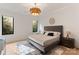 Bright bedroom with a gray upholstered bed, accent rug, and views from the windows at 3308 Carmel Rd, Charlotte, NC 28226