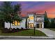 Stunning modern home with black framed windows, a balcony and black garage doors, surrounded by a lush lawn at 3308 Carmel Rd, Charlotte, NC 28226