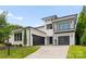 Daytime view of a modern home with a balcony, black framed windows and black garage doors on a well-manicured lawn at 3308 Carmel Rd, Charlotte, NC 28226