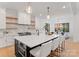 Modern kitchen featuring a large island, white cabinets, open shelving, and stainless steel appliances at 3308 Carmel Rd, Charlotte, NC 28226