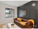 Cozy living room with a tufted leather sofa, designer wall paneling, and bright natural light at 3308 Carmel Rd, Charlotte, NC 28226