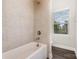 A neutral toned shower and bath combination has a window for natural light at 3332 Katherine Taylor Ct, Monroe, NC 28110